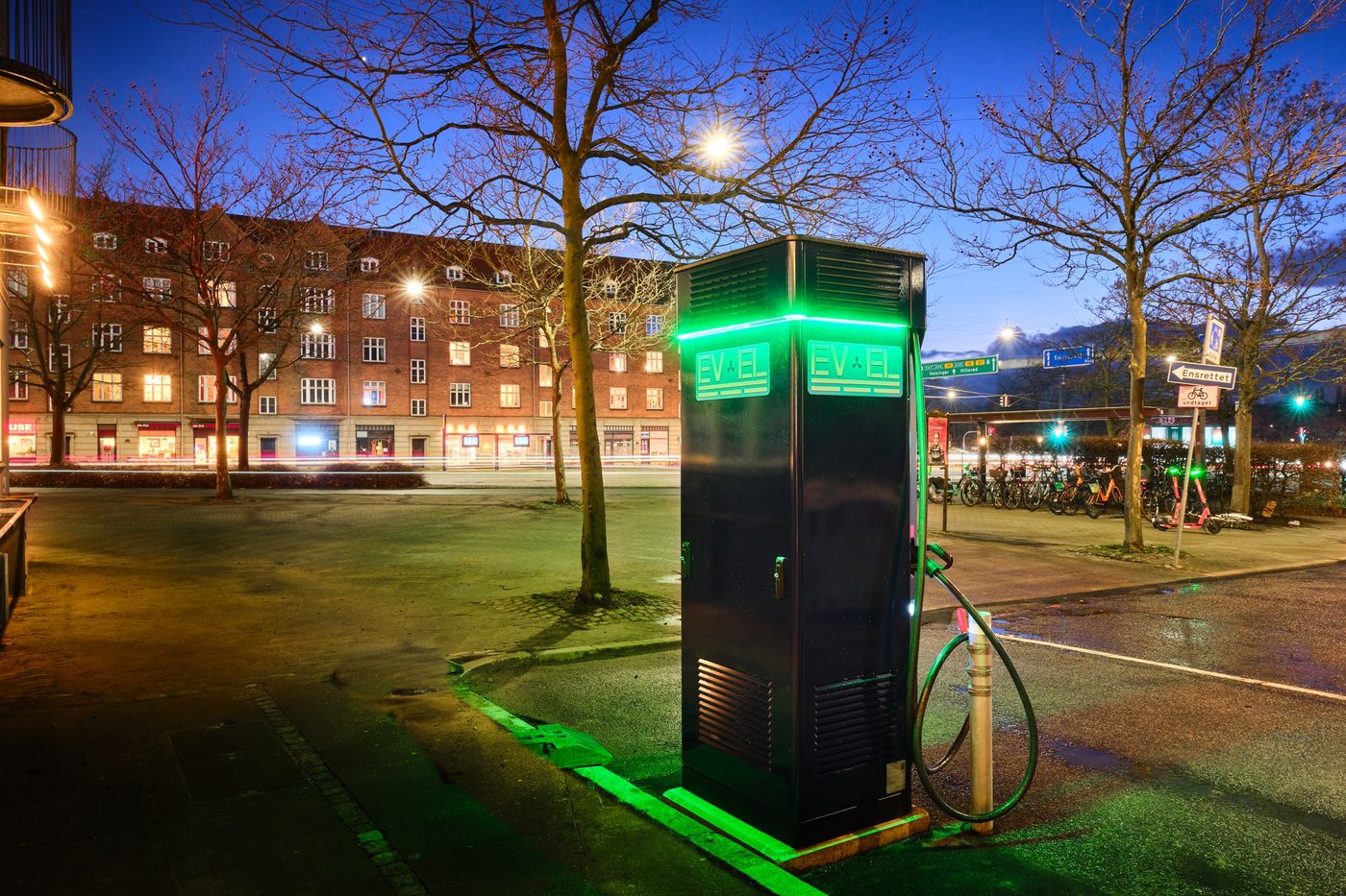 EV-EL fast charger glowing green on Hans Knudsens Plads in the evening