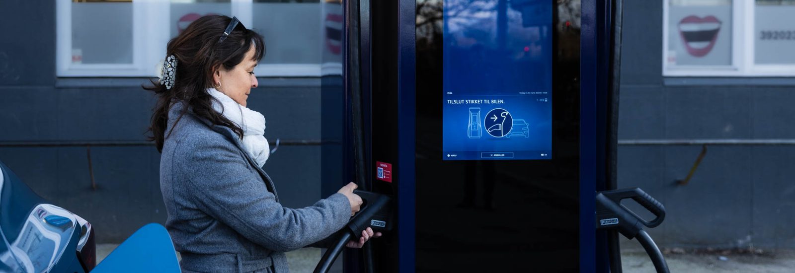Woman plugging in her electric car